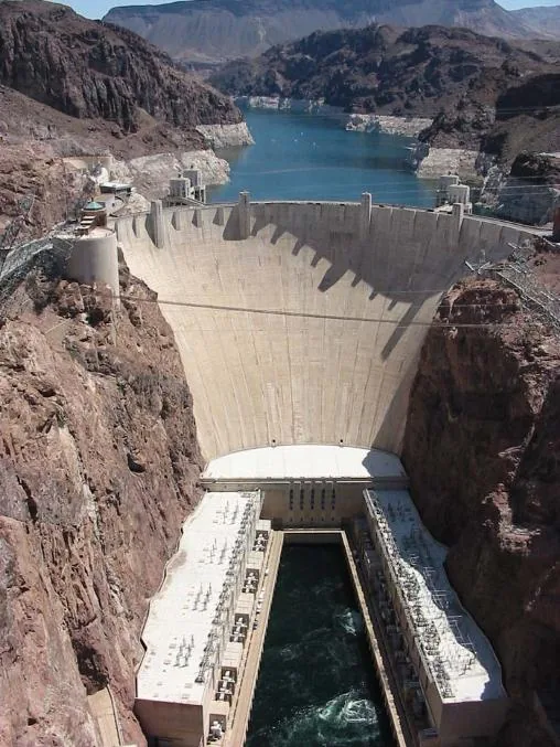 Hoover Dam's curved face seen from the rim, with Lake Mead behind it